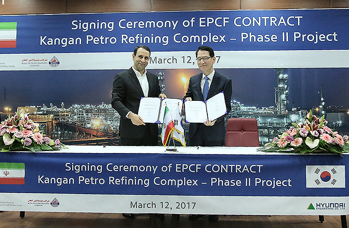 Ahdaf Investment Company CEO Asghar Arefi (left) and Hyundai Engineering CEO Sung Sang-rok hold up signed contracts after agreeing to the construction of new gas refineries in Iran, in Tehran on March 12.